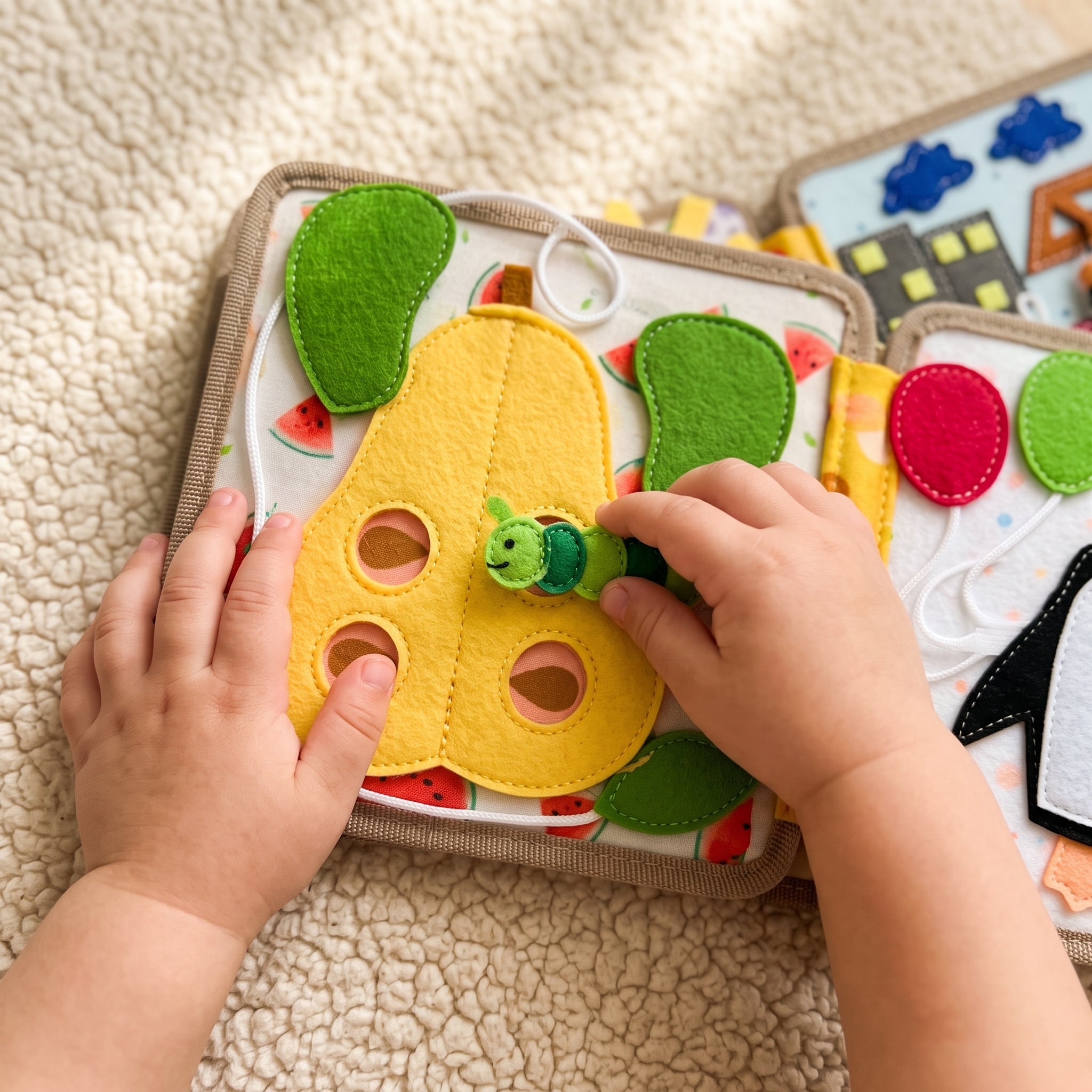 A toddler threading the felt caterpillar through the pear page of the deer busy book