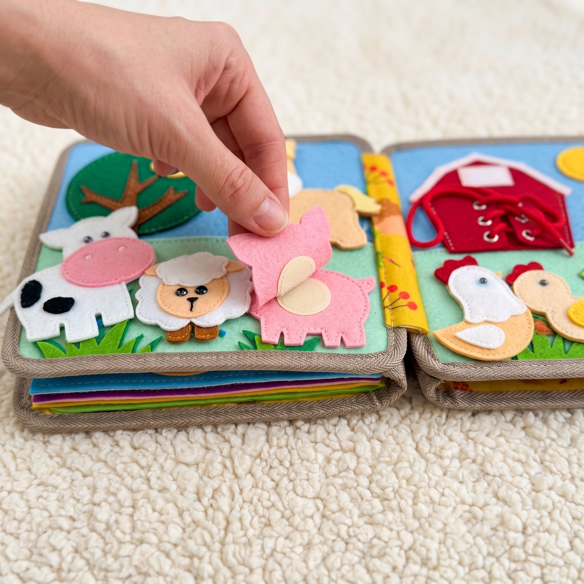 A felt piece lifted away from the page, showing the reinforced stitching underneath